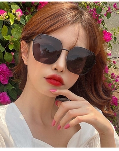 Close-up of stylish oversized black polarized sunglasses worn outdoors by a model