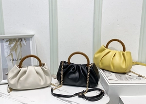 Detail of ruched cloud bags in beige, black and yellow with wooden handles and gold chains