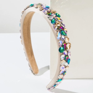 Détail d'un serre-tête baroque serti de strass multicolores sur tissu satiné