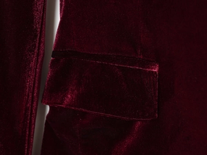 Vue macro de la texture en velours bordeaux et du rabat de poche sur le manteau