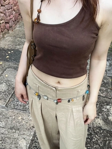 Detail view of ethnic style waist chain with red agate and turquoise on linen pants