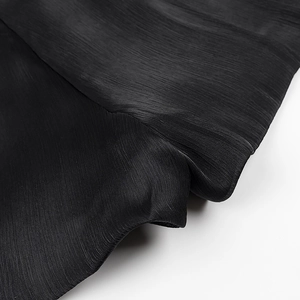 Close-up detail showing the pleated texture and drapery of the black lightweight fabric