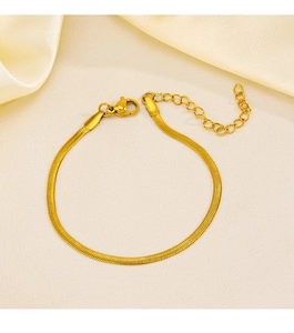 Detailed view of golden stainless steel flat snake chain bracelet on beige silk background