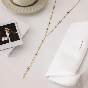 Détail du collier en Y doré avec cristaux ronds multicolores dans un décor élégant