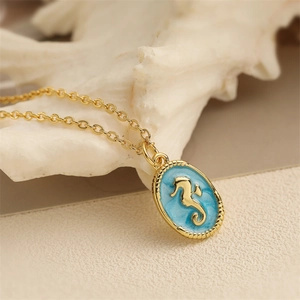 Golden seahorse oval pendant necklace with light blue enamel and textured bead edging