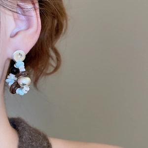 Detail of vintage bohemian beaded earrings with star engraving worn by a model
