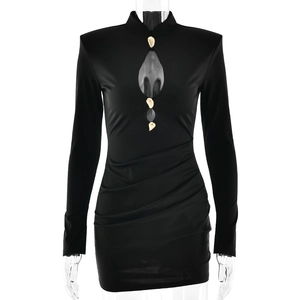 Robe noire moulante avec détails découpés, boucles métalliques dorées et textures plissées