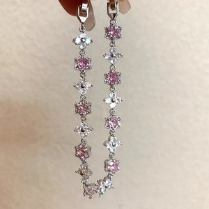 Détail macro du bracelet floral argenté avec zircons roses et éléments hexagonaux