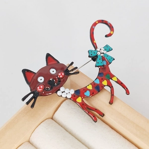 Colorful enamel cat brooch with red body, heart patterns and pearl bow detail