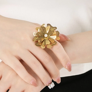 Bague fleur évidée dorée avec perle centrale sur la main, bijou fantaisie élégant