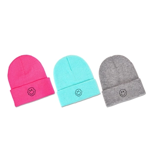 Winter knitted beanies with melting smiley face in rose, mint blue, and light grey colors