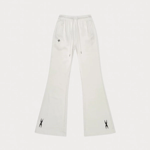 Detail of white cotton flare pants with drawstring waist and black embroidery on the hem