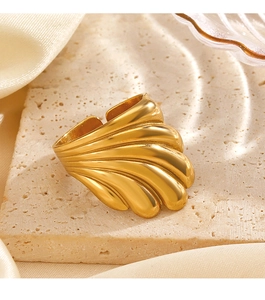 Détail d'une bague géométrique dorée sur socle en pierre naturelle avec fond en soie