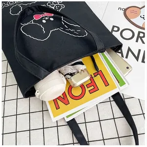 Black canvas tote bag with cartoon dog print showing large interior capacity for daily items