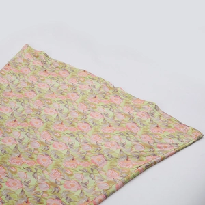 Gros plan détaillé du tissu en dentelle florale verte avec fleurs roses sur robe