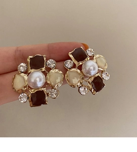Detailed macro view of vintage flower stud earring with pearl and black enamel inlay