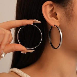 Minimalist large silver and black geometric hoop earrings for women on model