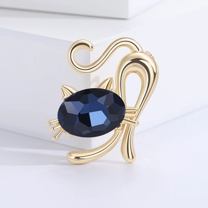 Fashionable crystal cat brooch with large navy blue gemstone and golden metal details