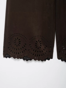 Détail d'une veste marron foncé texture daim avec ourlet ondulé ajouré au laser