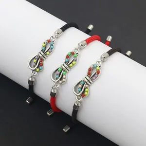 Detail of handmade braided infinity bracelets with colorful beads on white display