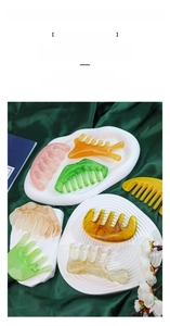 Detail of colorful resin scalp massage combs on decorative tray with silk background