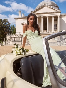 Elegant mint green bodycon maxi dress with floral detail on vintage car background