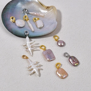 Baroque freshwater pearl pendants in various shapes and colors with metal clasps in a shell