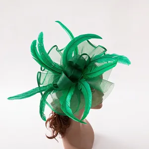 Detail of emerald green feather fascinator with mesh veil on mannequin head