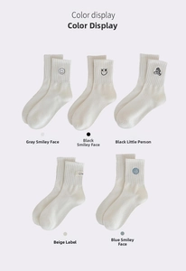 Nahaufnahme von fünf weißen Socken mit verschiedenen Cartoon-Stickereidetails