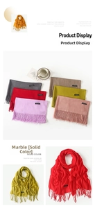 Detail of soft solid cashmere feel scarf with fringe edges and premium brand label