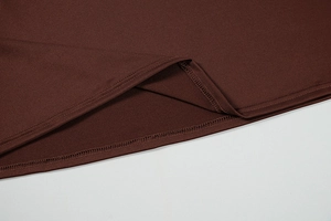 Detail of high-quality double-needle hem stitching on deep brown knitted dress fabric