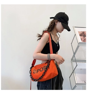 Détail du sac à bandoulière en nylon orange avec chaîne noire et imprimé SPORT mode