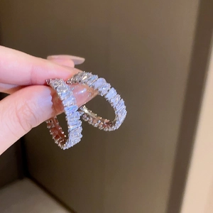 Close-up of silver hoop earrings with rectangular cubic zirconia stones in a micro setting