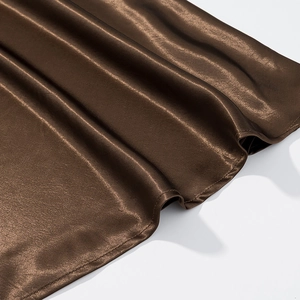 Detail of high-quality brown satin fabric with a silky glossy texture and soft draping