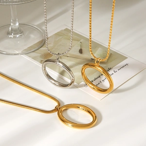 Detail of oval pendant necklaces in gold and silver with elegant twist and snake chains