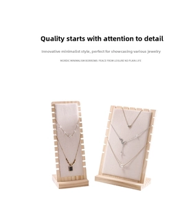 Detail view of wood necklace display stands with beige fabric slots for jewelry