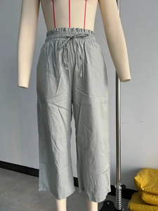 Detailed view of elastic high waist with adjustable drawstring on linen wide leg trousers