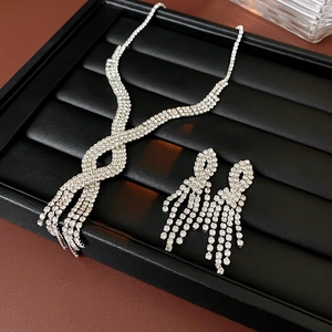 Close-up of a silver tassel necklace and earring set with shimmering crystals