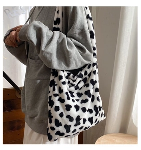 Detail of soft faux fur tote bag featuring a high-capacity black and white cow print design