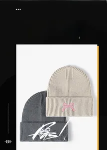 Close-up of thick knitted beanies with pink bow embroidery detail for winter