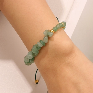 Adjustable hand-woven bracelet featuring natural green stone chips and gold metal beads