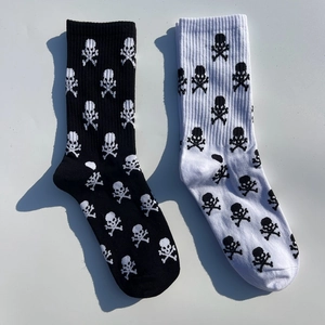 Détail de chaussettes mi-mollet en coton avec motifs de crânes en noir et blanc