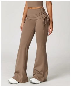 Detail of high-waist flared yoga pants with drawstring ruching in brown fabric