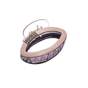Pink and clear oval claw clip with rhinestones for elegant hair styling on white background