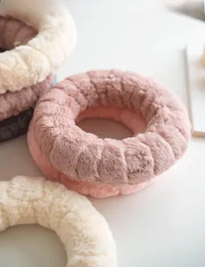 Detailed view of soft wool felt wreaths in pastel pink, beige and grey plush textures