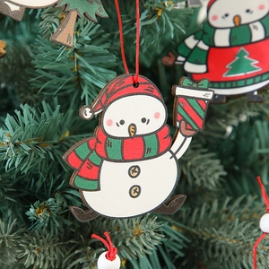 Wooden snowman ornament hanging on a Christmas tree branch with festive decorations