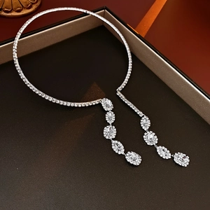 Close-up of a silver tassel necklace with rhinestones and butterfly drops in a gift box