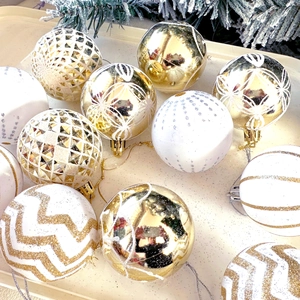Macro detail of gold and white patterned Christmas ornaments with glitter and pine needles
