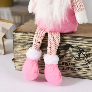 Detail eines rosa Weihnachtswichtels mit Paillettenbeinen und weißem Kunstfellbart