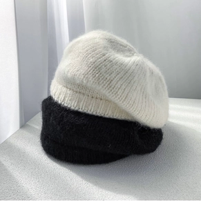 Detailed texture of white and black mohair knit berets stacked for winter comfort